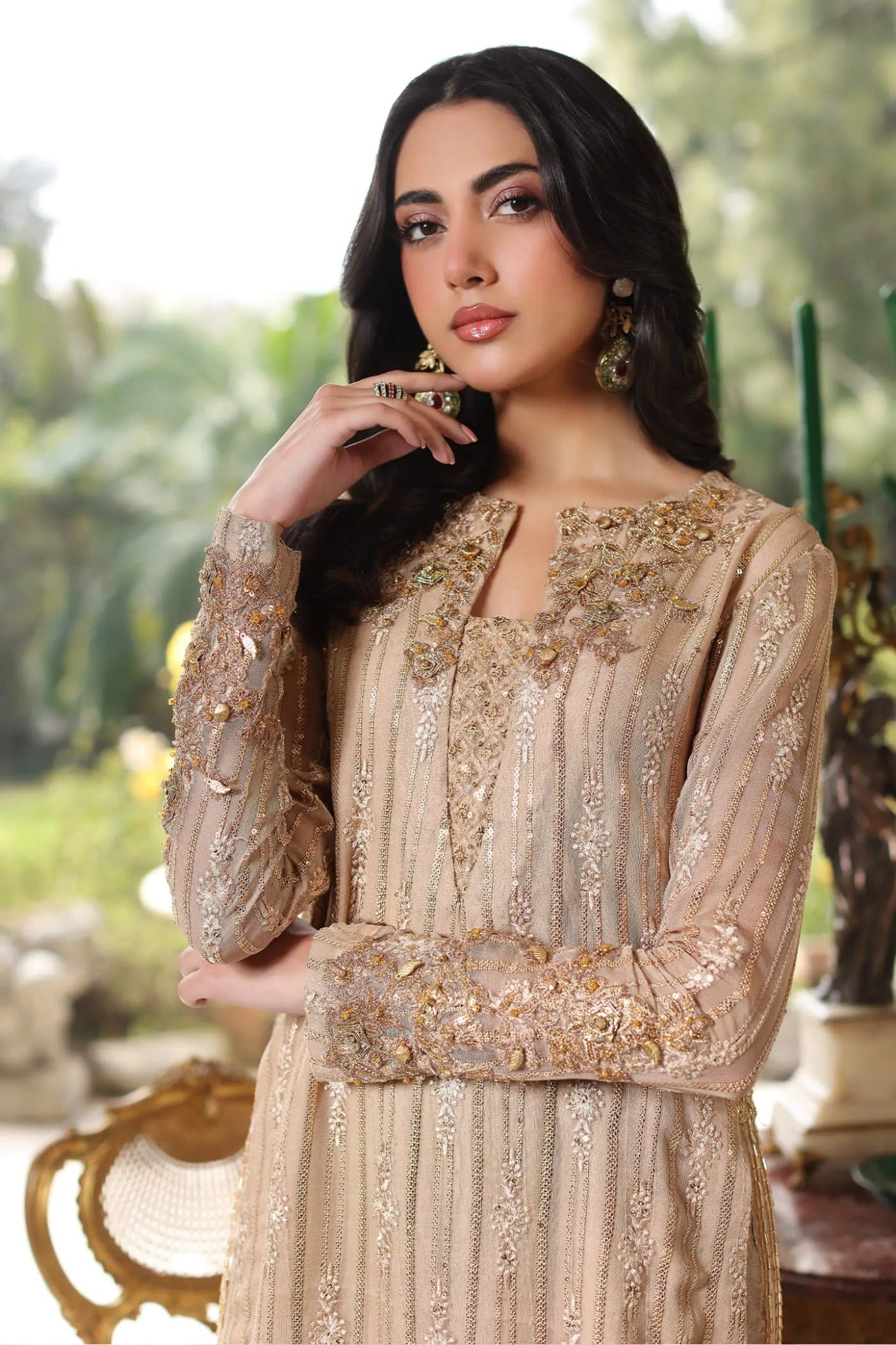 Model wearing a gold ENCHANTÉ dress from Musferah Saad's ENCHANTE Eid collection '24, showcasing Pakistani clothes online in the UK.