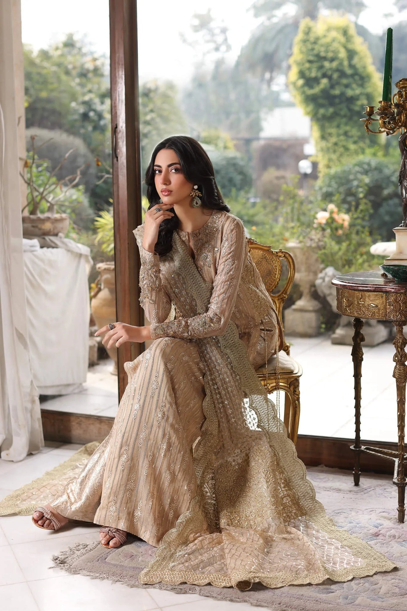 Model wearing a gold ENCHANTÉ dress from Musferah Saad's ENCHANTE Eid collection '24, showcasing Pakistani clothes online in the UK.