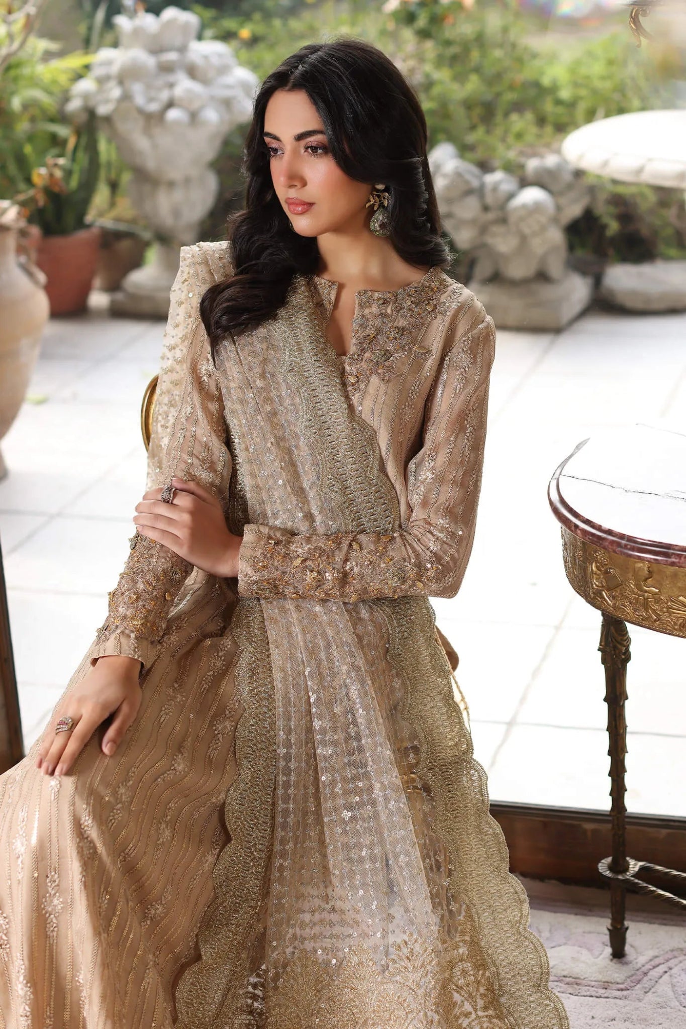 Model wearing a gold ENCHANTÉ dress from Musferah Saad's ENCHANTE Eid collection '24, showcasing Pakistani clothes online in the UK.