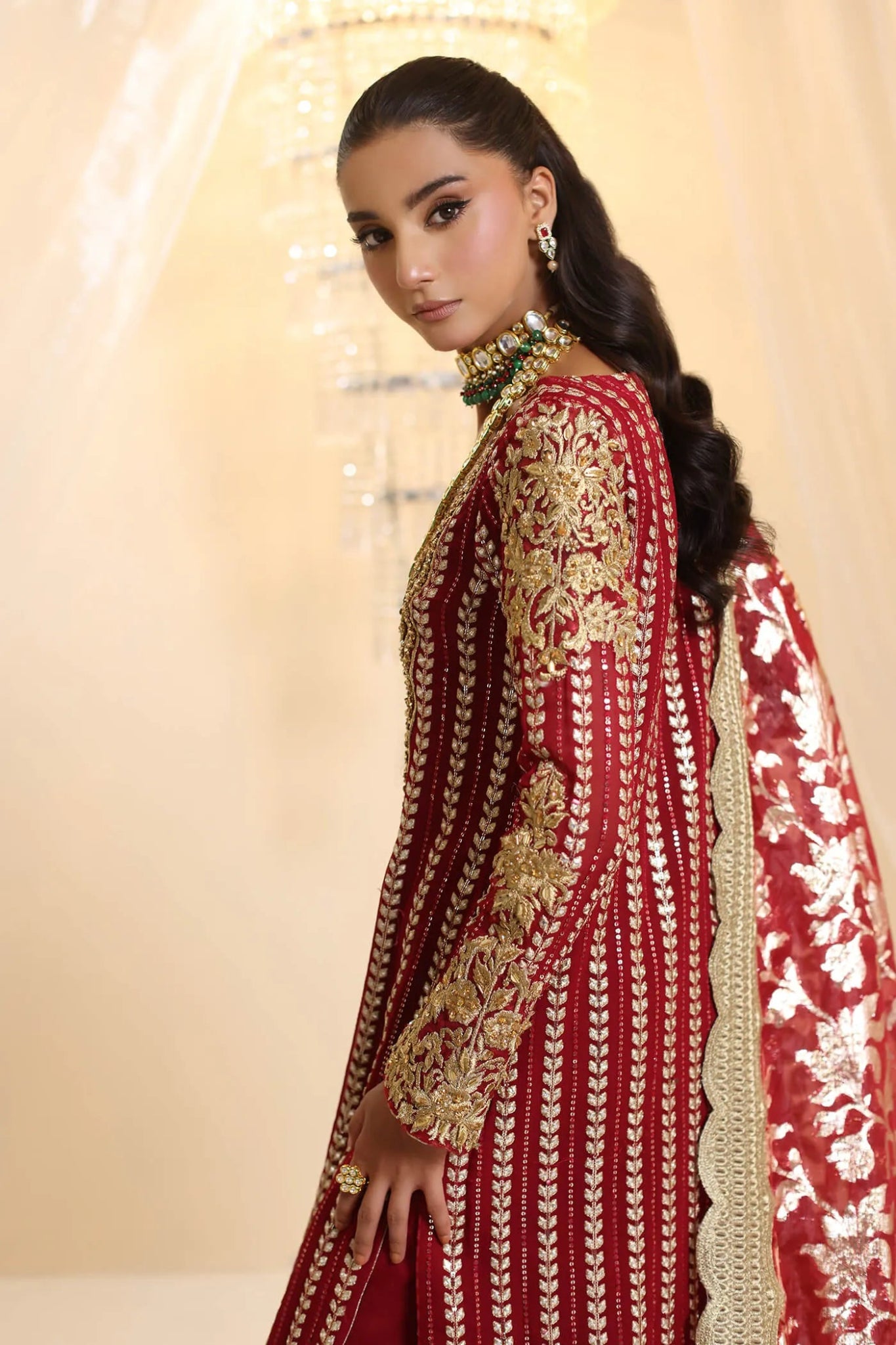 Model wearing Musferah Saad Crimson Royale dress in deep red and gold from the Ethereal Dream Formals collection, perfect for Pakistani wedding clothes online in the UK.