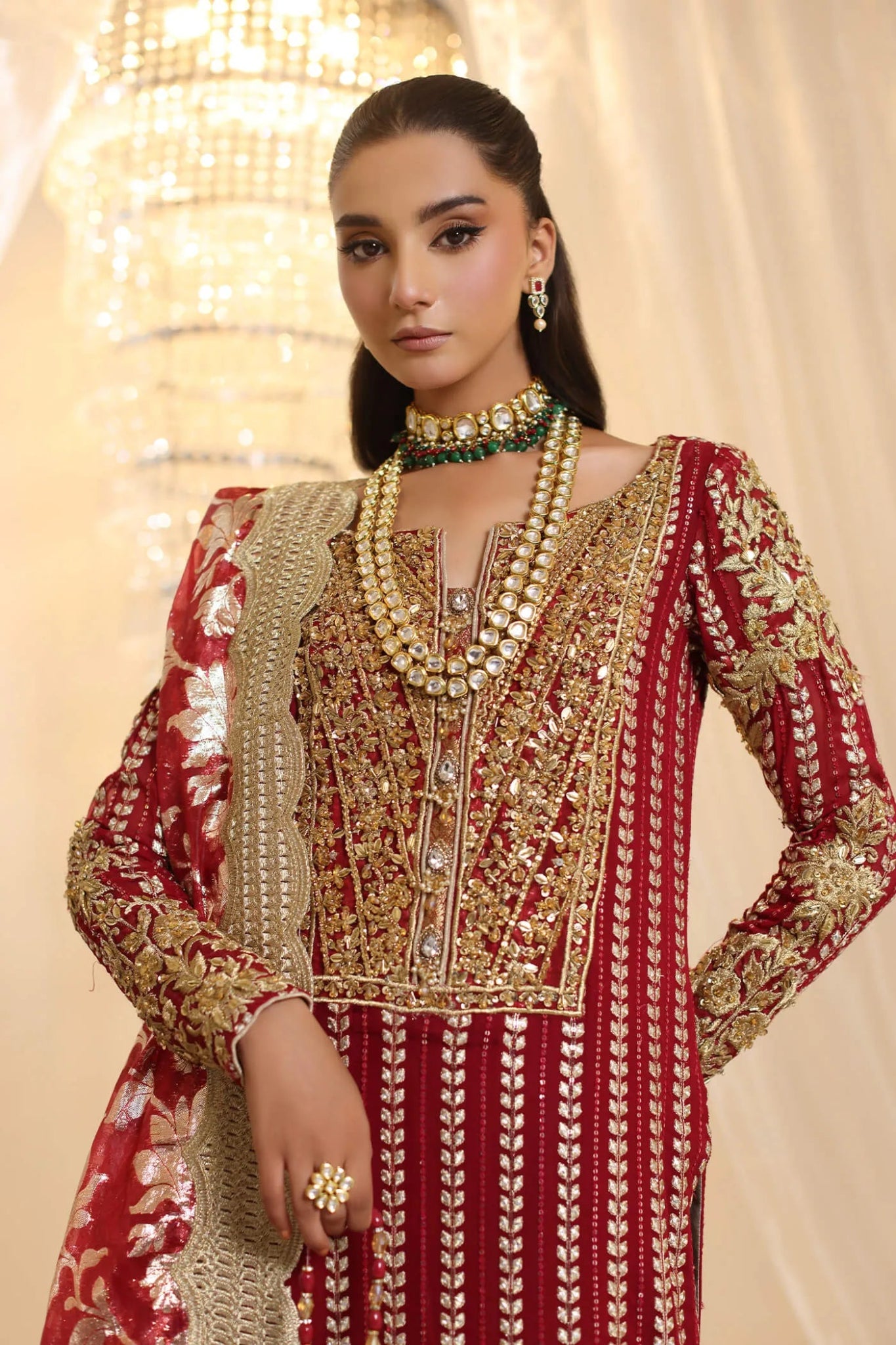 Model wearing Musferah Saad Crimson Royale dress in deep red and gold from the Ethereal Dream Formals collection, perfect for Pakistani wedding clothes online in the UK.