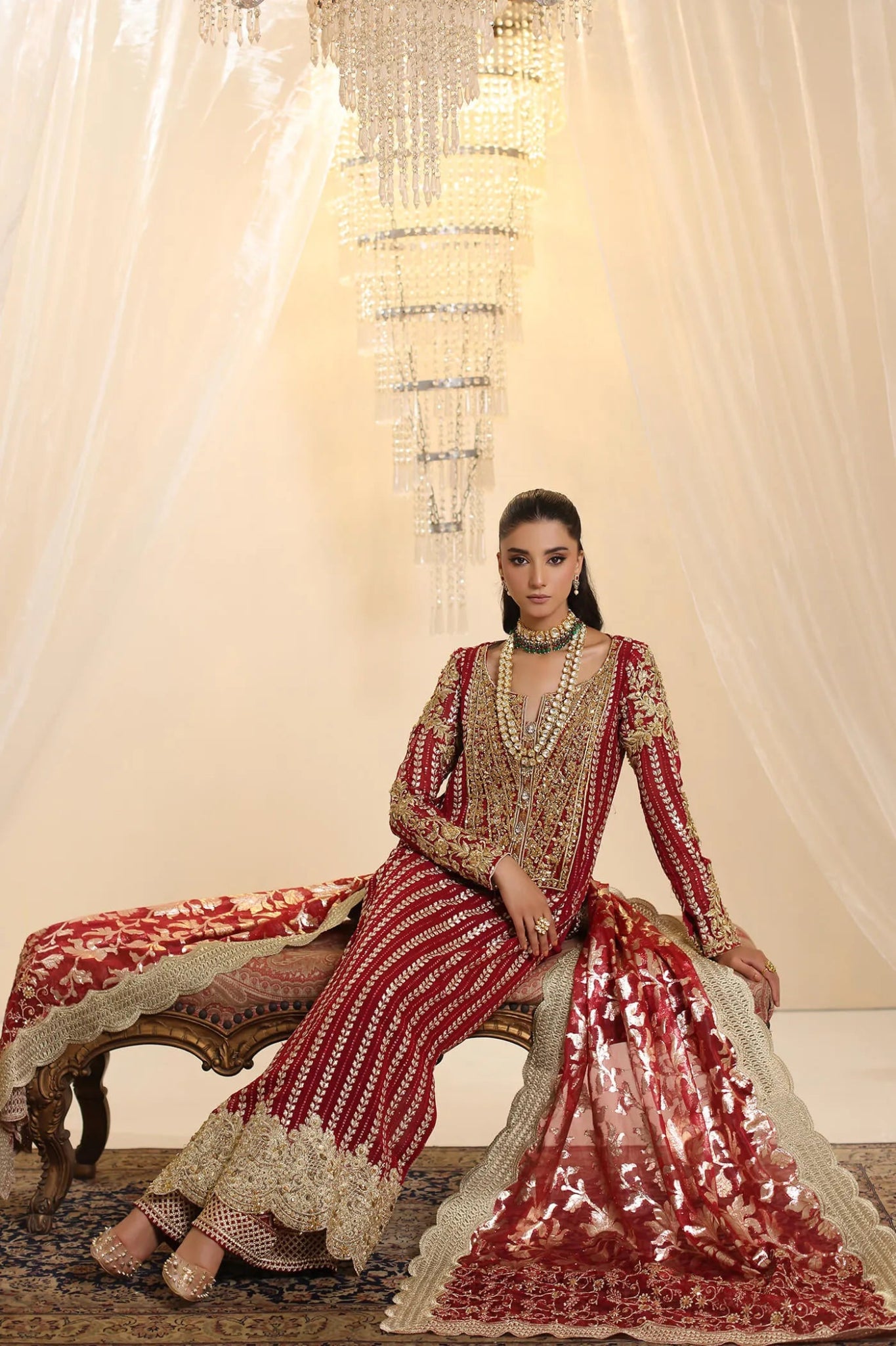 Model wearing Musferah Saad Crimson Royale dress in deep red and gold from the Ethereal Dream Formals collection, perfect for Pakistani wedding clothes online in the UK.