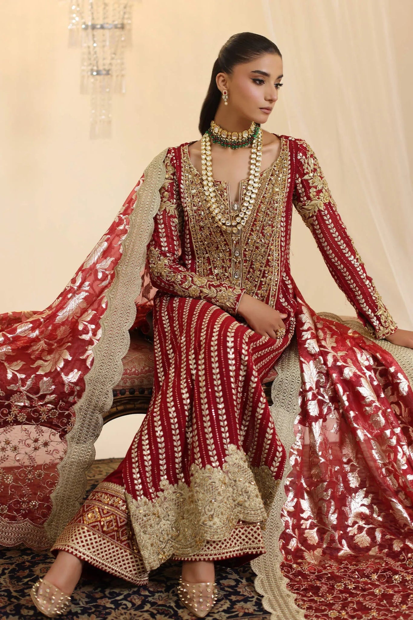 Model wearing Musferah Saad Crimson Royale dress in deep red and gold from the Ethereal Dream Formals collection, perfect for Pakistani wedding clothes online in the UK.