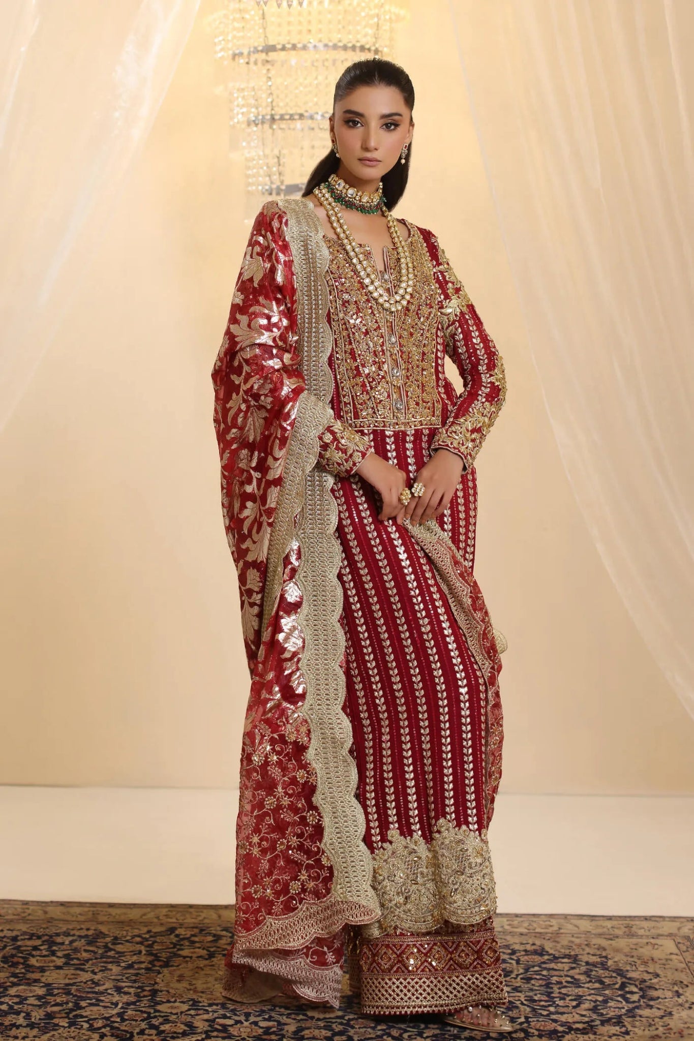 Model wearing Musferah Saad Crimson Royale dress in deep red and gold from the Ethereal Dream Formals collection, perfect for Pakistani wedding clothes online in the UK.