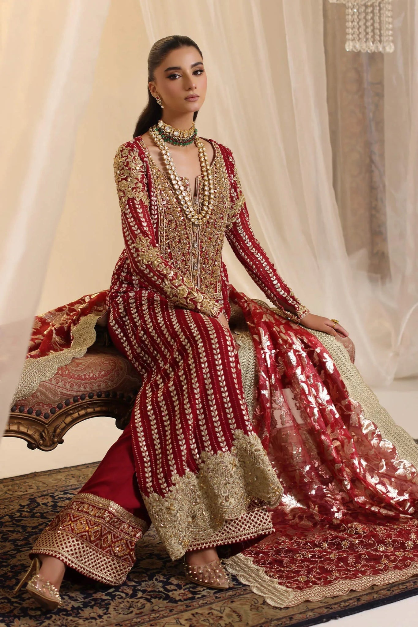 Model wearing Musferah Saad Crimson Royale dress in deep red and gold from the Ethereal Dream Formals collection, perfect for Pakistani wedding clothes online in the UK.