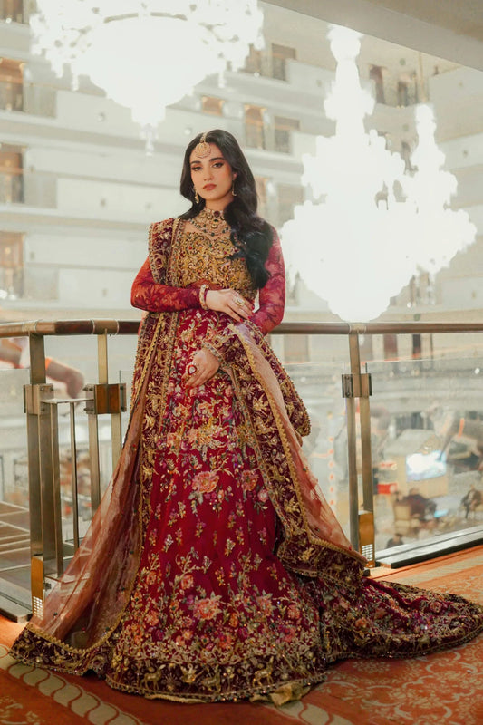 Model wearing Musferah Saad Royal Goddess, rich red Pakistani bridal attire, UK.
