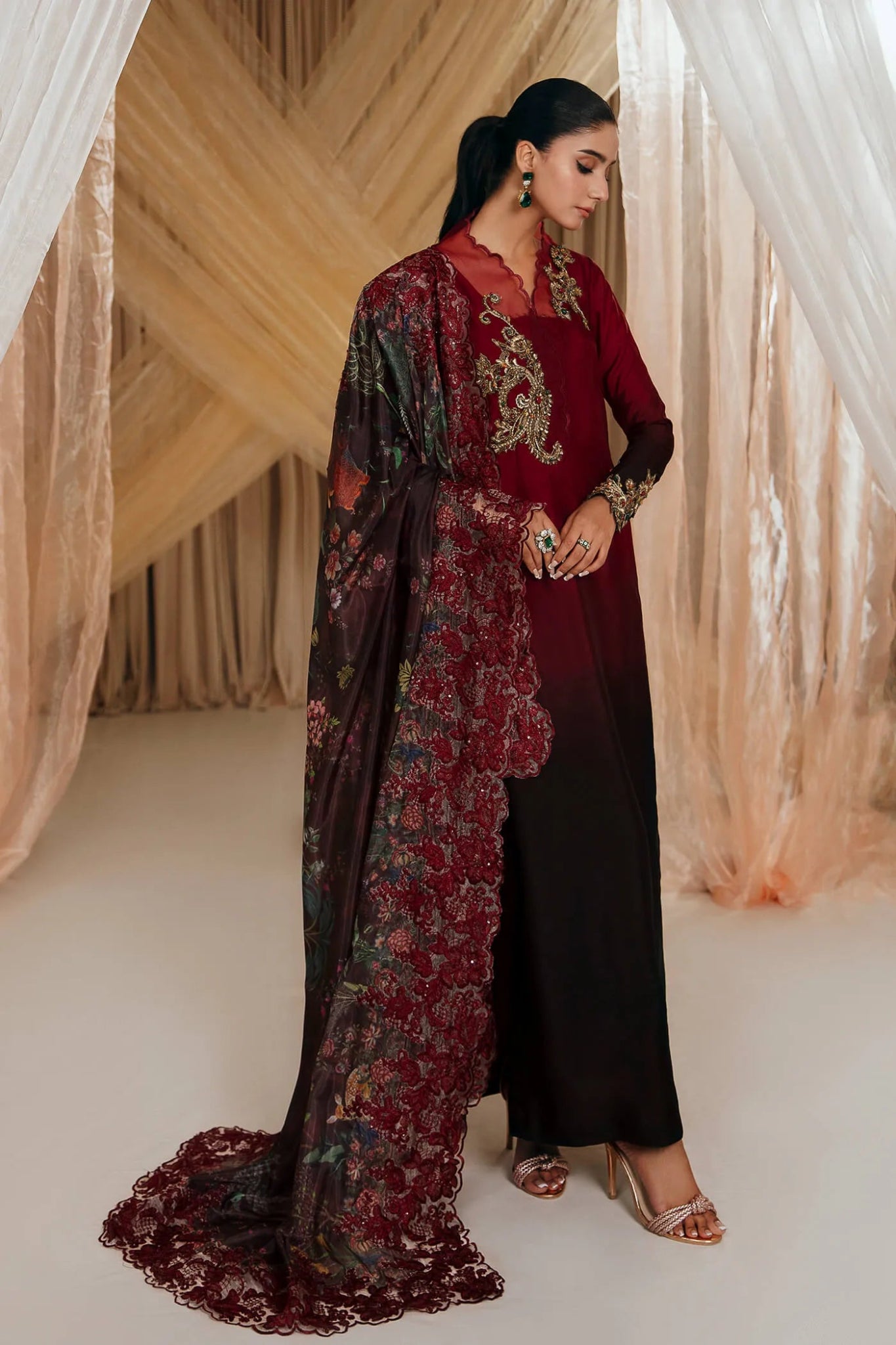 Model wearing Faiza Saqlain's Crimson Rose dress from the Musferah Saad Mystere Eid Collection '24. A striking maroon Pakistani Eid dress with gold embroidery and a beautifully detailed dupatta, ideal for Pakistani designer clothes shoppers in the UK.