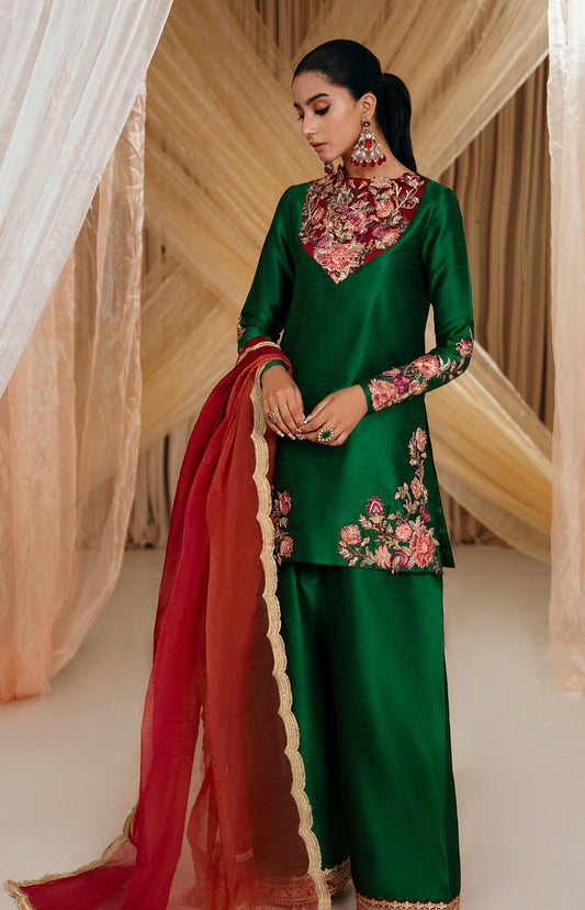 Model wearing Faiza Saqlain's Emerald Garden dress from the Musferah Saad Mystere Eid Collection '24. A stunning green Pakistani Eid dress adorned with rich embroidery, perfect for those seeking Pakistani designer clothes in the UK.