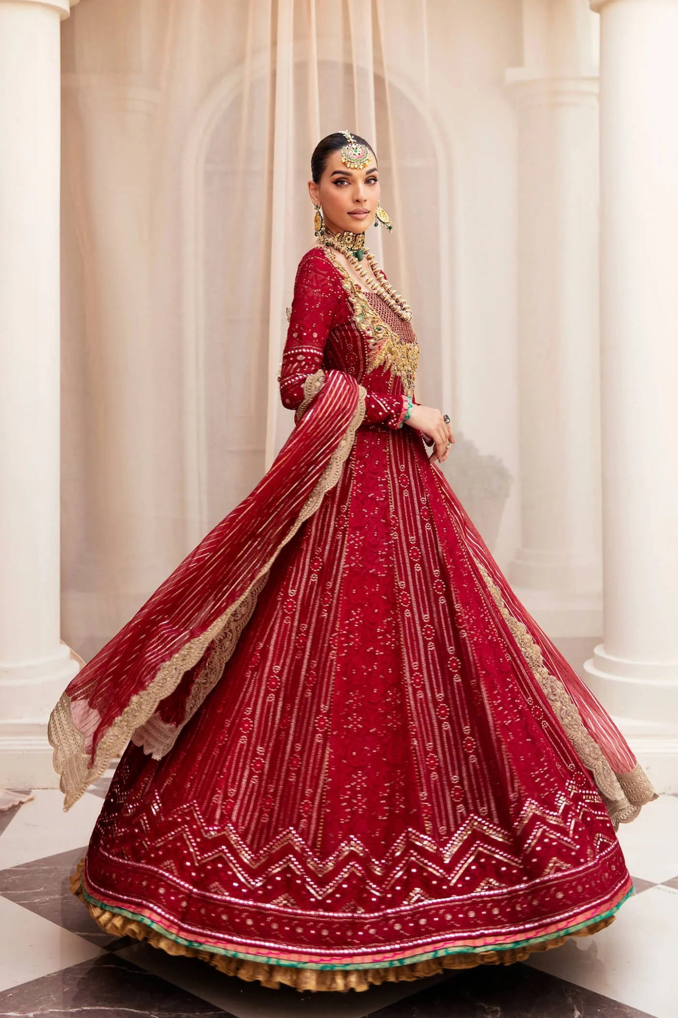 Model wearing a luxurious deep red SCARLET ELEGANCE dress from Musferah Saad's Symphony '23 collection, highlighting Pakistani clothes online in the UK.