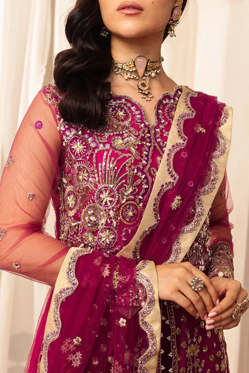 Model wearing a vibrant fuchsia wedding formal dress from Mushq. Pakistani wedding clothes online in the UK.