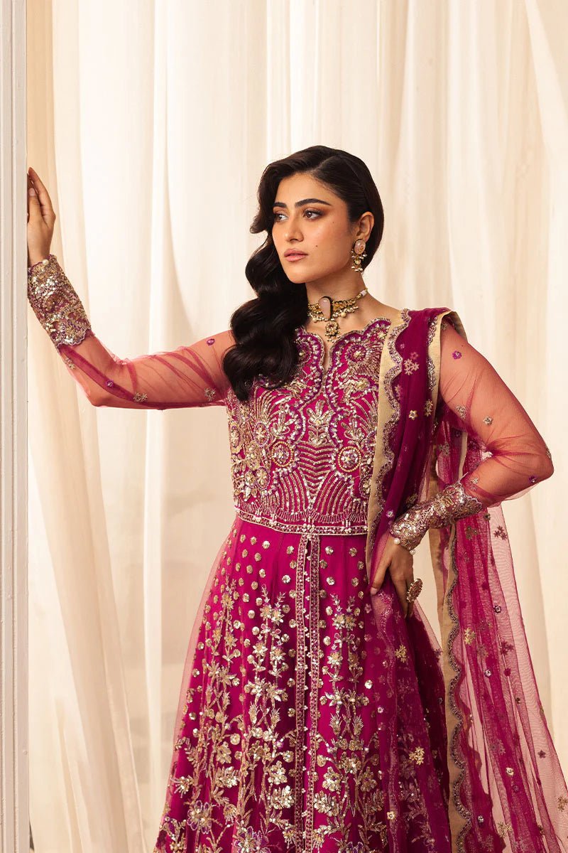 Model wearing a vibrant fuchsia wedding formal dress from Mushq. Pakistani wedding clothes online in the UK.