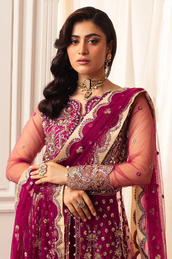 Model wearing a vibrant fuchsia wedding formal dress from Mushq. Pakistani wedding clothes online in the UK.