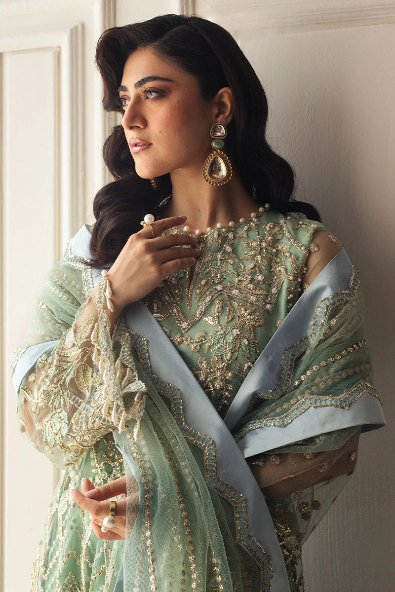 Model wearing a light pistachio green embellished wedding formal dress from Mushq. Pakistani wedding clothes online in the UK.