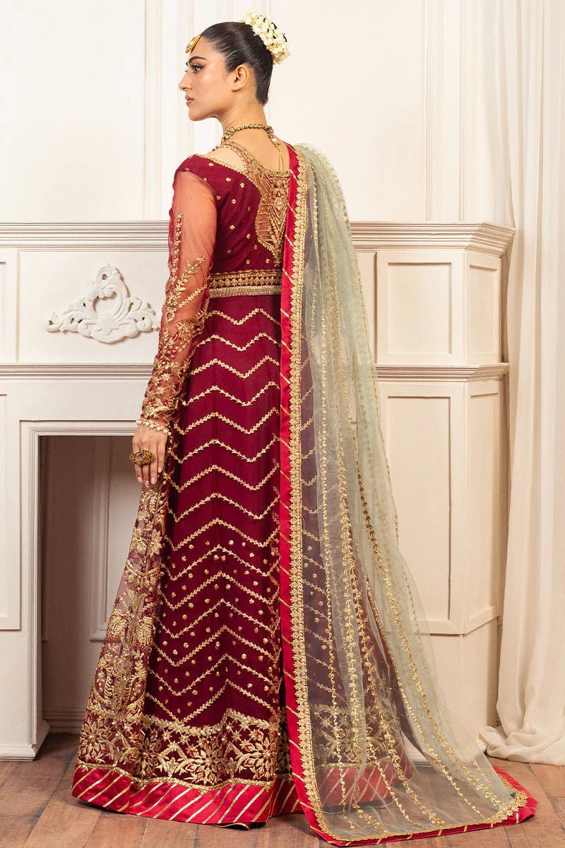 Model wearing a deep red and gold intricately embroidered Asian wedding formal dress, "Scarlet," from Mushq. Pakistani wedding clothes online in the UK.