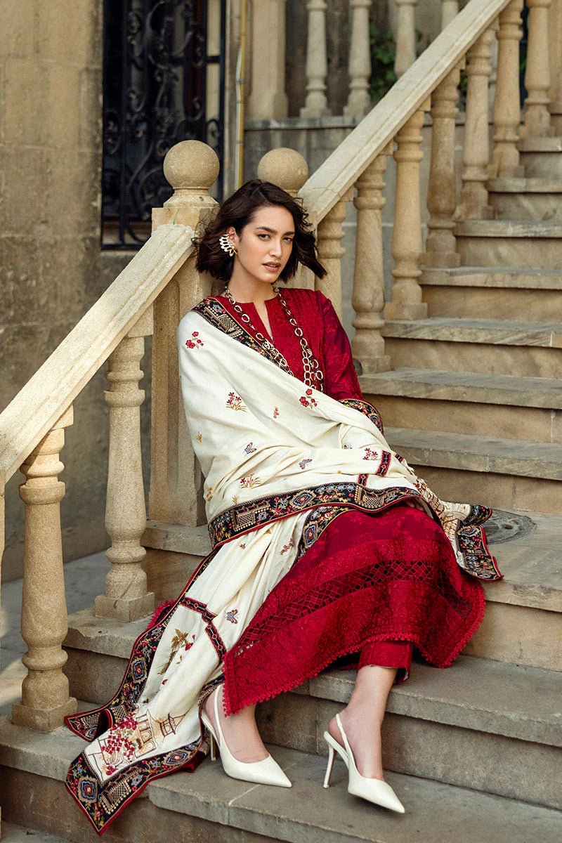 Model wearing Mushq Broadway A Walk to Remember Flying Kiss, a rich red dress with intricate patterns and a cream shawl, ideal for winter casual wear. Available for Pakistani clothes online in the UK.