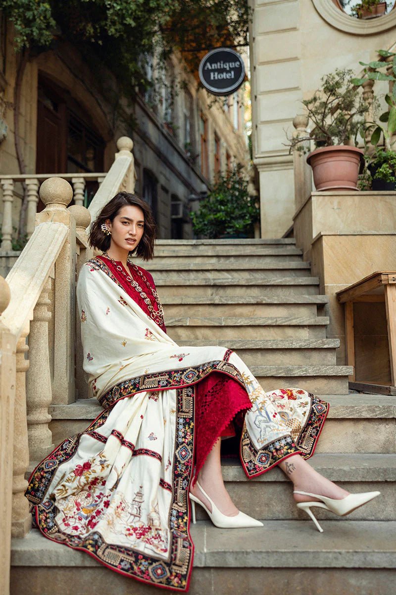 Model wearing Mushq Broadway A Walk to Remember Flying Kiss, a rich red dress with intricate patterns and a cream shawl, ideal for winter casual wear. Available for Pakistani clothes online in the UK.