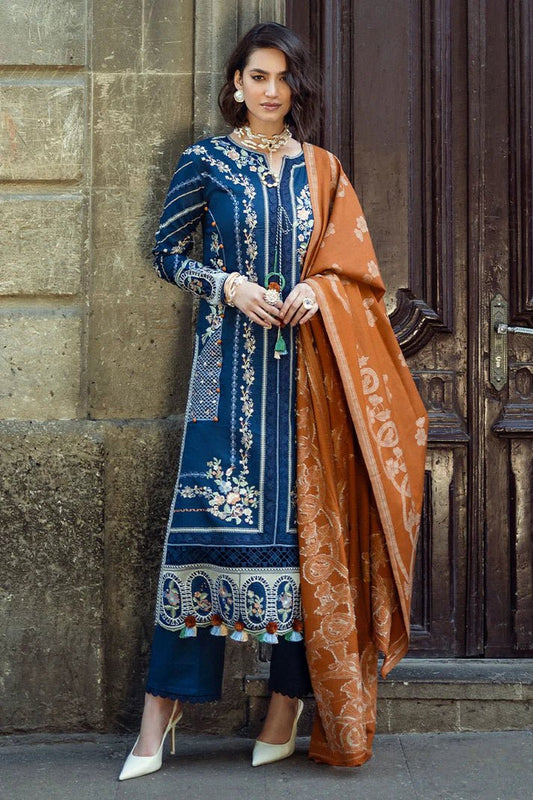 Model wearing Mushq Broadway A Walk to Remember Sweet Surrender, a blue dress with intricate embroidery and an orange shawl, perfect for winter casual wear. Available for Pakistani clothes online in the UK.