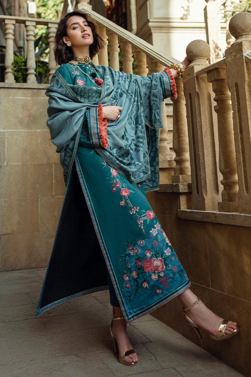 Model wearing Mushq Broadway A Walk to Remember Whispered Secrets, a teal dress adorned with floral embroidery and tassel accents, perfect for winter casual wear. Available for Pakistani clothes online in the UK.