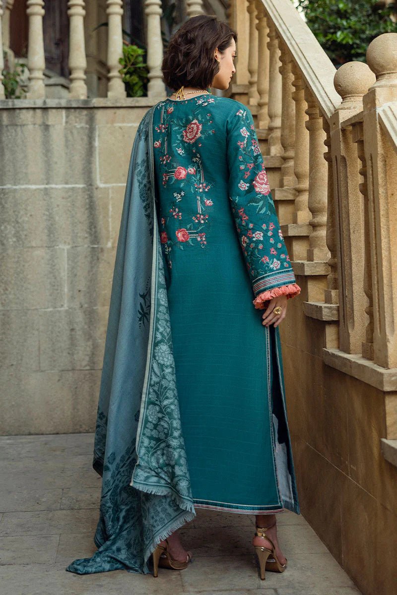 Model wearing Mushq Broadway A Walk to Remember Whispered Secrets, a teal dress adorned with floral embroidery and tassel accents, perfect for winter casual wear. Available for Pakistani clothes online in the UK.