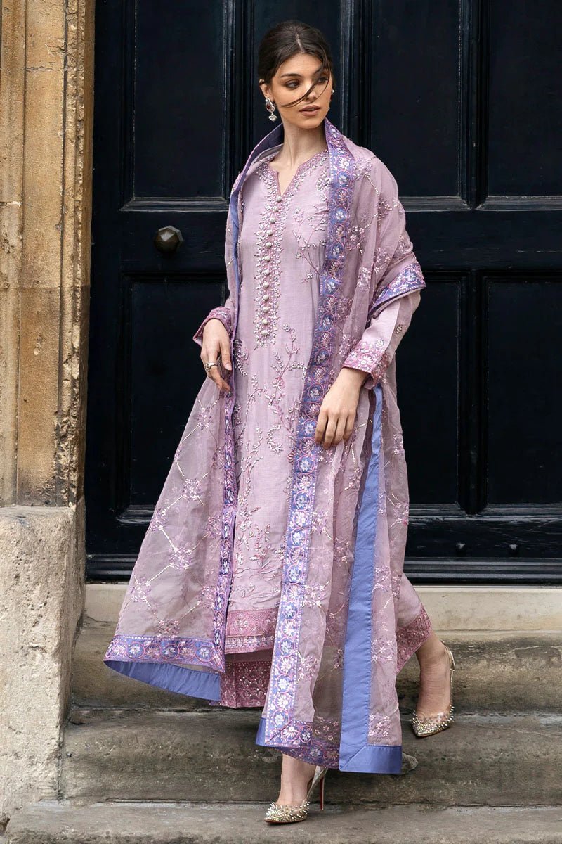 Model wearing a blue Aurora Bloom dress from Mushq. Features intricate floral embroidery, paired with matching pants and dupatta, showcasing Pakistani clothes online in the UK, wedding clothes.