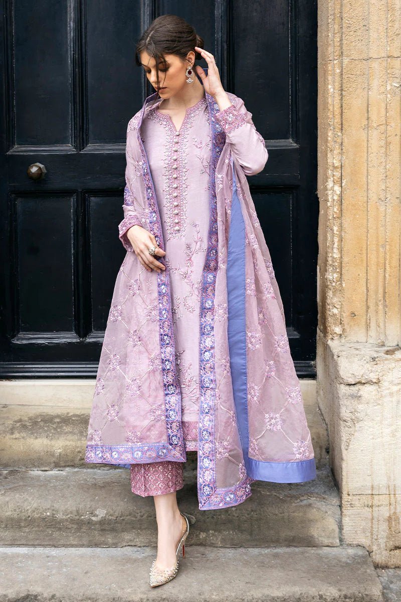 Model wearing a blue Aurora Bloom dress from Mushq. Features intricate floral embroidery, paired with matching pants and dupatta, showcasing Pakistani clothes online in the UK, wedding clothes.