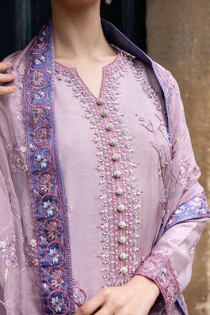 Model wearing a blue Aurora Bloom dress from Mushq. Features intricate floral embroidery, paired with matching pants and dupatta, showcasing Pakistani clothes online in the UK, wedding clothes.