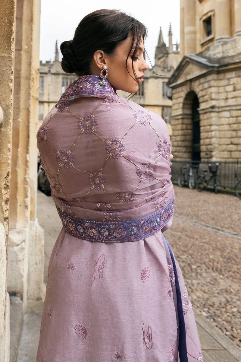 Model wearing a blue Aurora Bloom dress from Mushq. Features intricate floral embroidery, paired with matching pants and dupatta, showcasing Pakistani clothes online in the UK, wedding clothes.