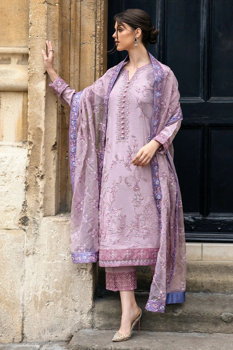 Model wearing a blue Aurora Bloom dress from Mushq. Features intricate floral embroidery, paired with matching pants and dupatta, showcasing Pakistani clothes online in the UK, wedding clothes.