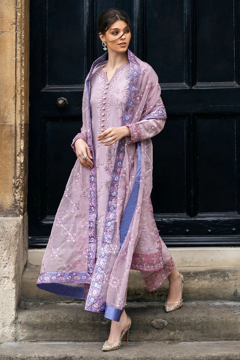 Model wearing a blue Aurora Bloom dress from Mushq. Features intricate floral embroidery, paired with matching pants and dupatta, showcasing Pakistani clothes online in the UK, wedding clothes.