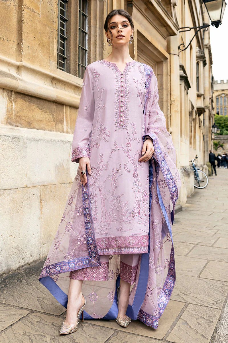 Model wearing a blue Aurora Bloom dress from Mushq. Features intricate floral embroidery, paired with matching pants and dupatta, showcasing Pakistani clothes online in the UK, wedding clothes.