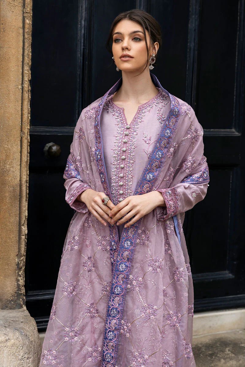 Model wearing a blue Aurora Bloom dress from Mushq. Features intricate floral embroidery, paired with matching pants and dupatta, showcasing Pakistani clothes online in the UK, wedding clothes.