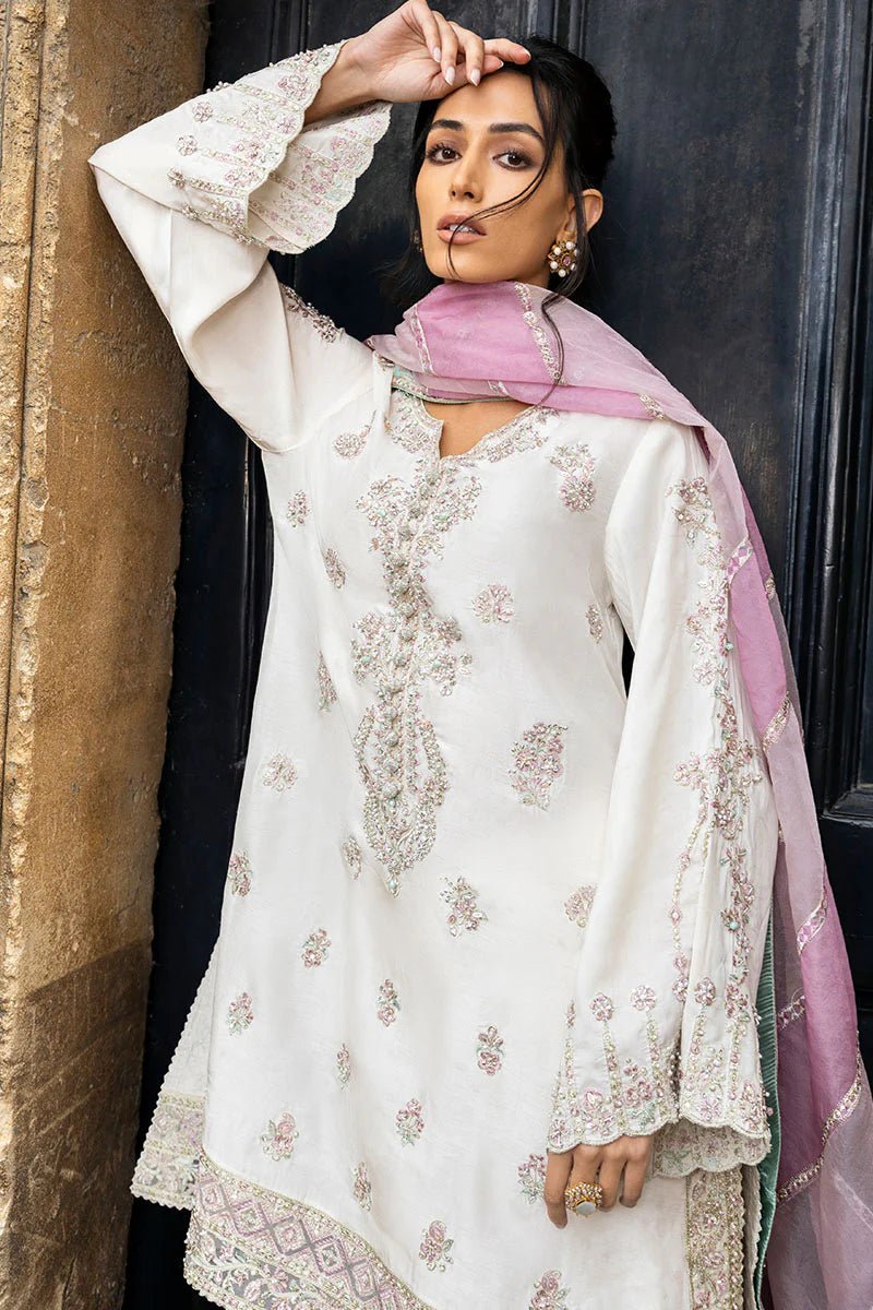 Model wearing a white Luminous Lace dress with intricate embroidery and a lavender dupatta from Mushq, perfect for weddings. Available for Pakistani clothes online in the UK.