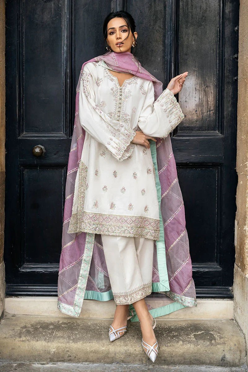 Model wearing a white Luminous Lace dress with intricate embroidery and a lavender dupatta from Mushq, perfect for weddings. Available for Pakistani clothes online in the UK.