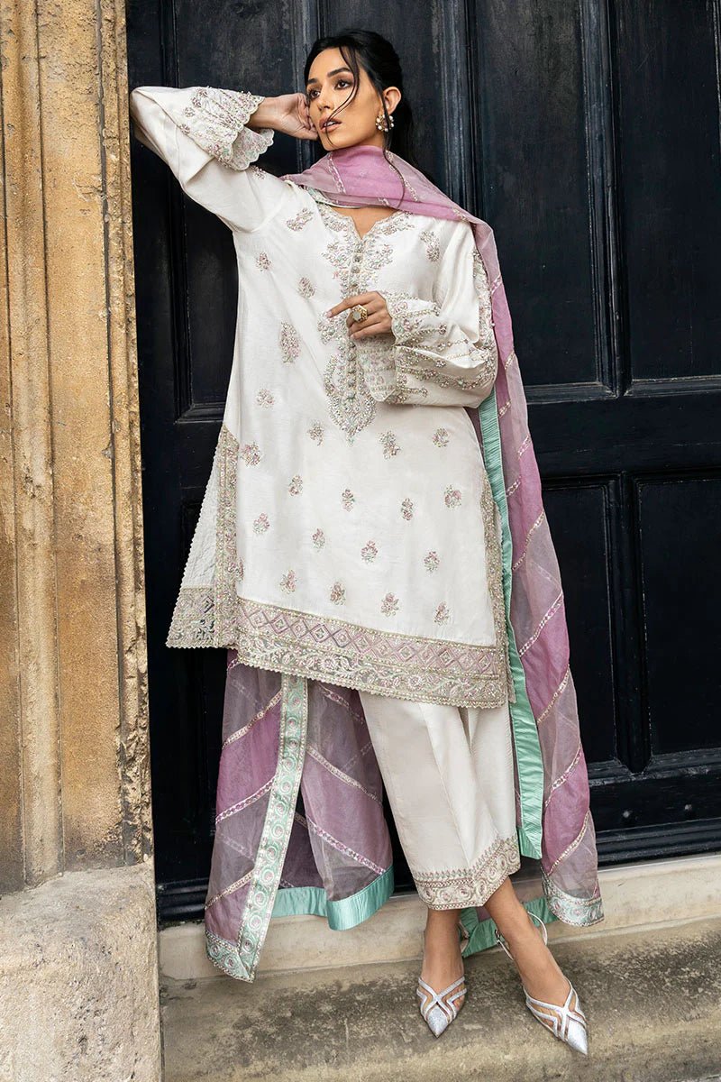 Model wearing a white Luminous Lace dress with intricate embroidery and a lavender dupatta from Mushq, perfect for weddings. Available for Pakistani clothes online in the UK.