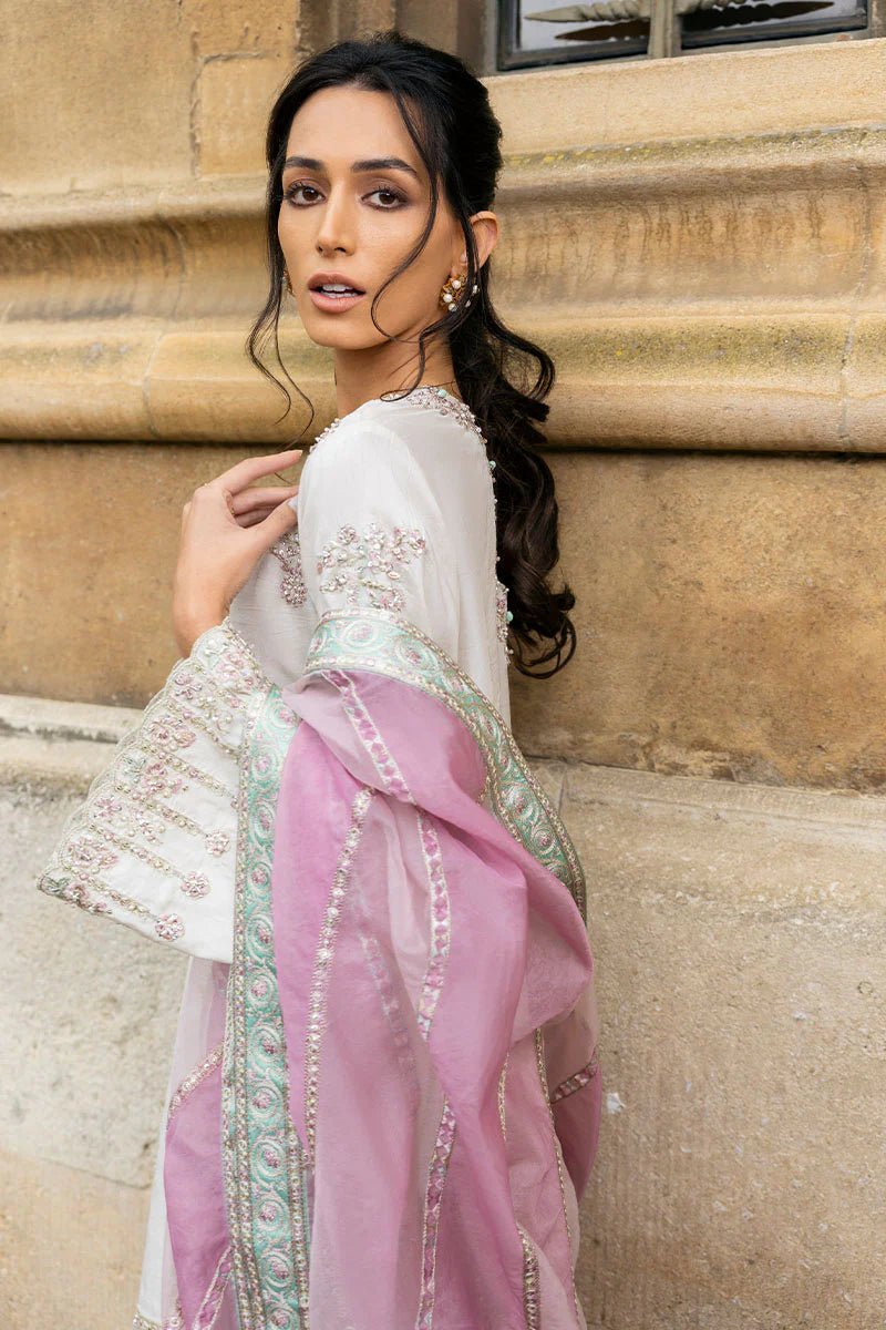 Model wearing a white Luminous Lace dress with intricate embroidery and a lavender dupatta from Mushq, perfect for weddings. Available for Pakistani clothes online in the UK.