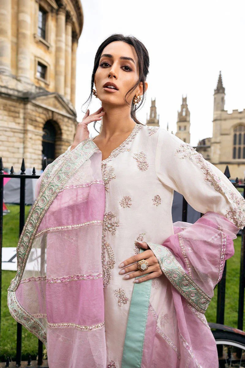 Model wearing a white Luminous Lace dress with intricate embroidery and a lavender dupatta from Mushq, perfect for weddings. Available for Pakistani clothes online in the UK.