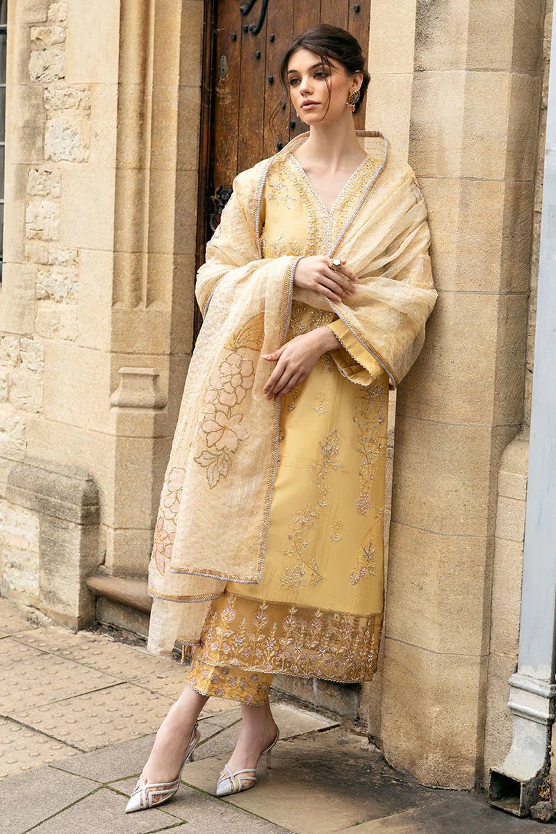 Model wearing a yellow Lyravia dress from Mushq, featuring intricate floral embroidery. Keywords: Mushq, Pakistani clothes online in UK, wedding clothes.