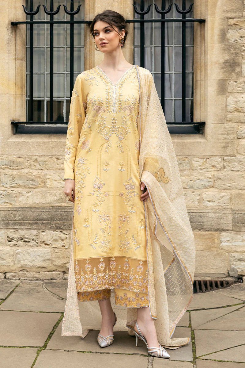 Model wearing a yellow Lyravia dress from Mushq, featuring intricate floral embroidery. Keywords: Mushq, Pakistani clothes online in UK, wedding clothes.