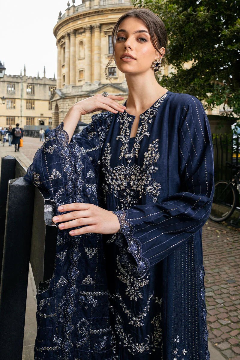 Model wearing Mushq Celestine The Oxford Edit 24 Starlight dress, featuring intricate embroidery and embellishments in a deep navy color. Perfect for wedding attire, available for Pakistani clothes online in the UK.