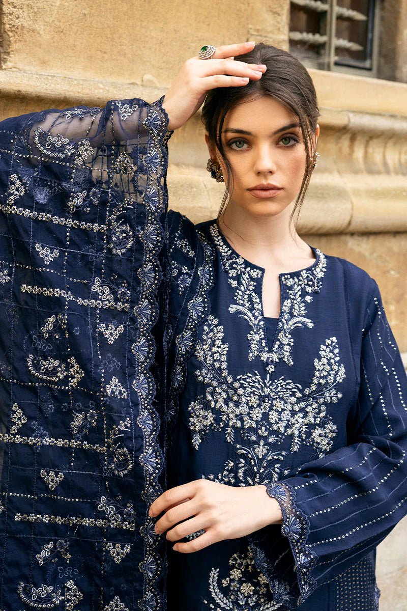 Model wearing Mushq Celestine The Oxford Edit 24 Starlight dress, featuring intricate embroidery and embellishments in a deep navy color. Perfect for wedding attire, available for Pakistani clothes online in the UK.