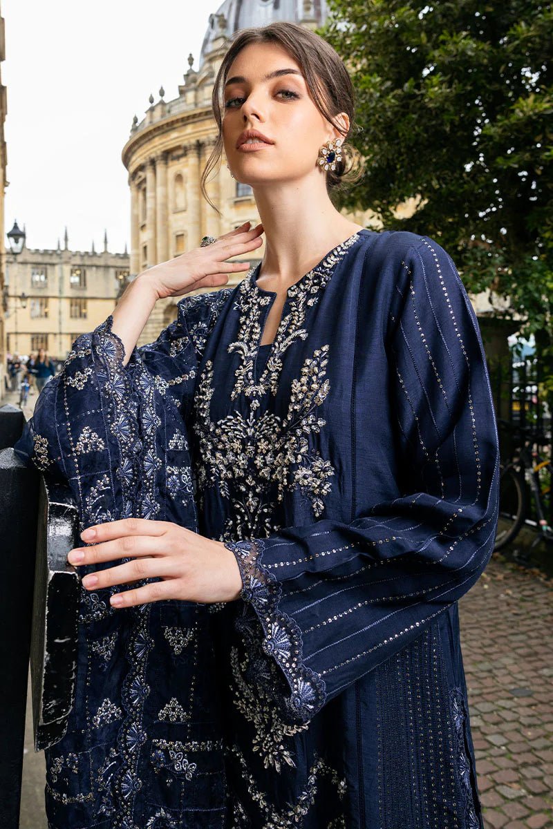 Model wearing Mushq Celestine The Oxford Edit 24 Starlight dress, featuring intricate embroidery and embellishments in a deep navy color. Perfect for wedding attire, available for Pakistani clothes online in the UK.