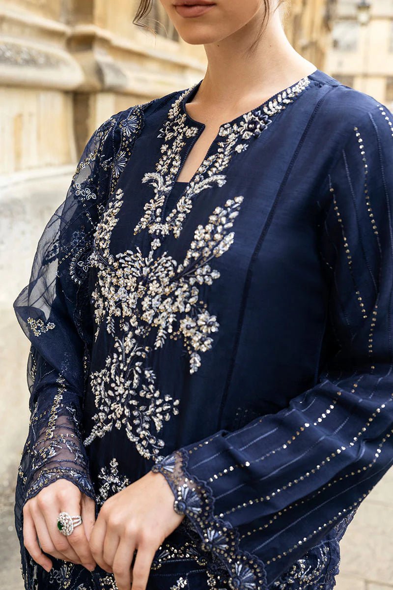 Model wearing Mushq Celestine The Oxford Edit 24 Starlight dress, featuring intricate embroidery and embellishments in a deep navy color. Perfect for wedding attire, available for Pakistani clothes online in the UK.