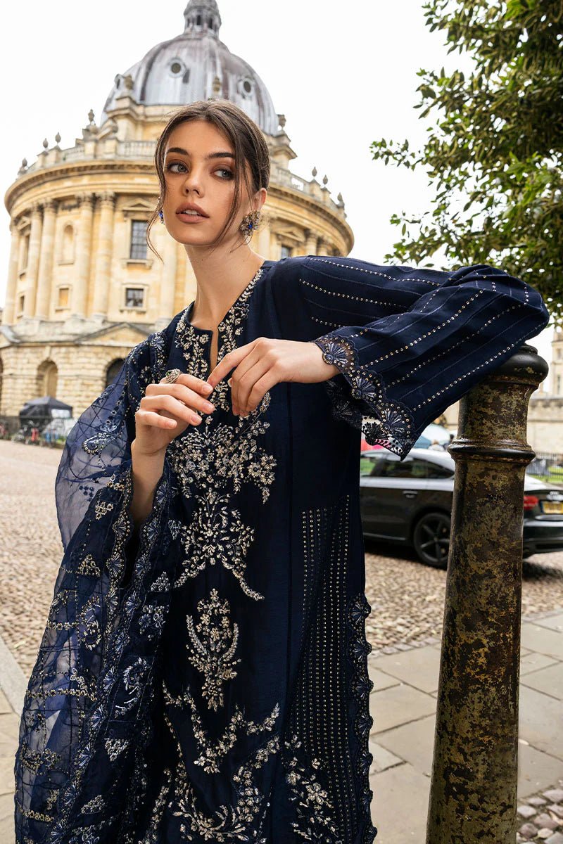 Model wearing Mushq Celestine The Oxford Edit 24 Starlight dress, featuring intricate embroidery and embellishments in a deep navy color. Perfect for wedding attire, available for Pakistani clothes online in the UK.