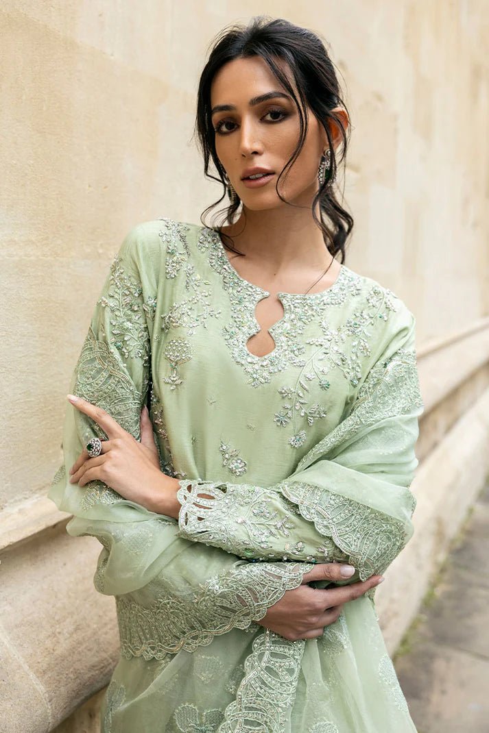 Model wearing a green Stella Grace dress from Mushq. Features intricate embroidery, paired with matching pants and dupatta, showcasing Pakistani clothes online in the UK, wedding clothes.