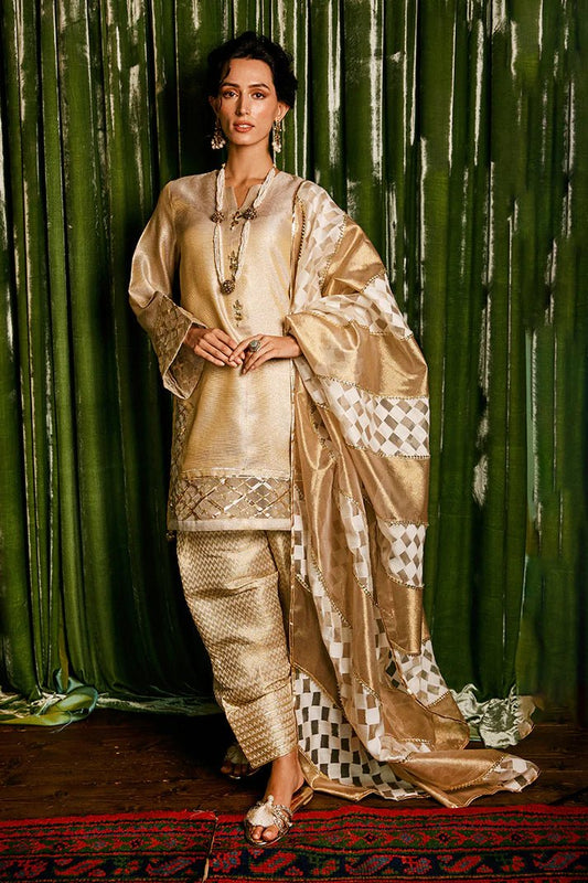 Model wearing a golden Basanti outfit from Mushq with intricate gota detailing, showcasing Pakistani designer clothes online in the UK, perfect for weddings.