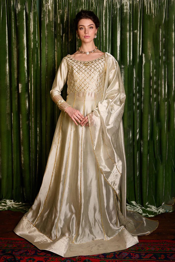 Model wearing a luxurious golden Lashkara dress from Mushq with intricate gota detailing, ideal for Pakistani weddings, available online in the UK.