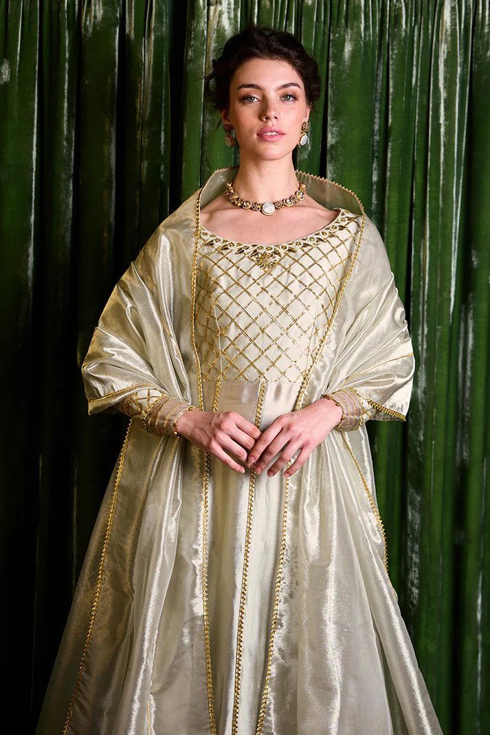 Model wearing a luxurious golden Lashkara dress from Mushq with intricate gota detailing, ideal for Pakistani weddings, available online in the UK.