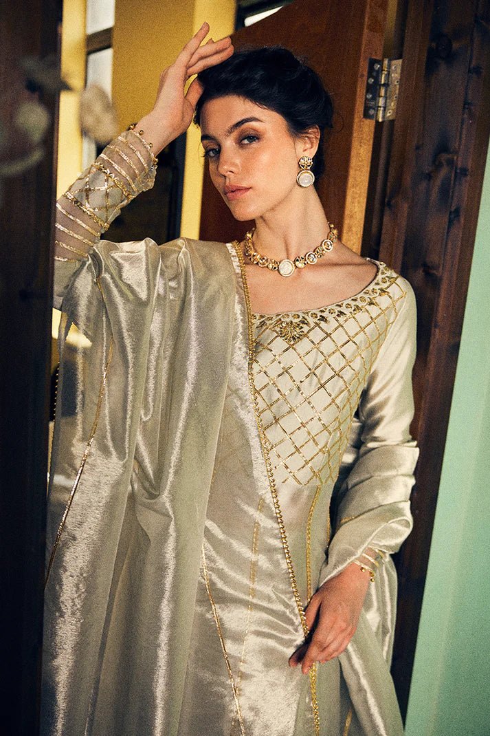 Model wearing a luxurious golden Lashkara dress from Mushq with intricate gota detailing, ideal for Pakistani weddings, available online in the UK.