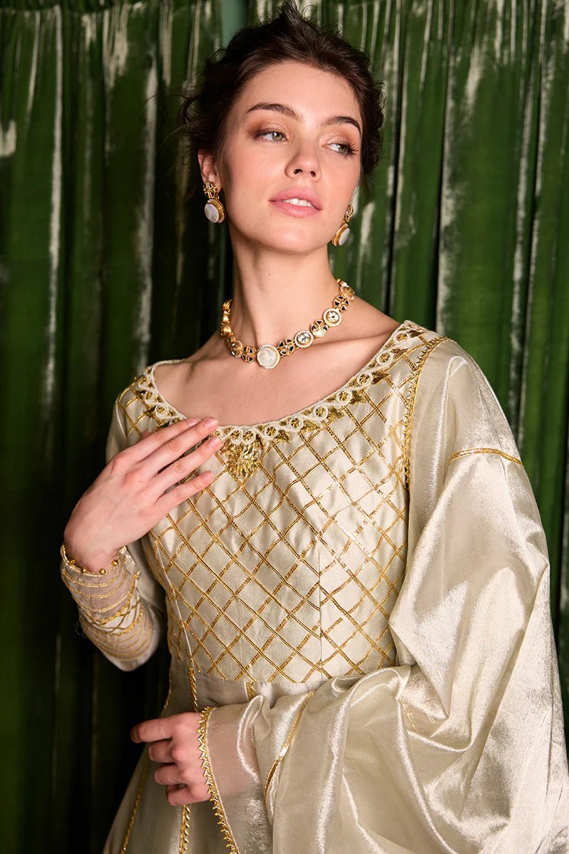 Model wearing a luxurious golden Lashkara dress from Mushq with intricate gota detailing, ideal for Pakistani weddings, available online in the UK.