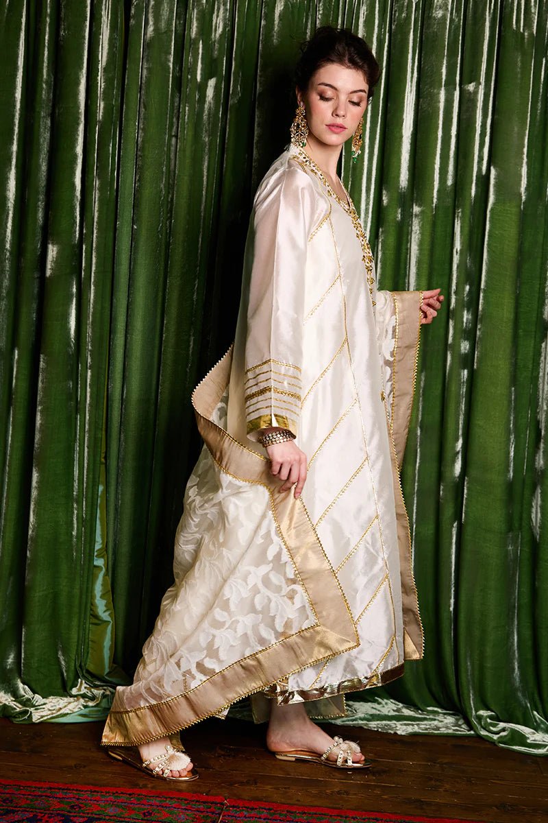 Model wearing a luxurious ivory and gold Moti dress from Mushq with elegant gota detailing, perfect for Pakistani weddings, available online in the UK.